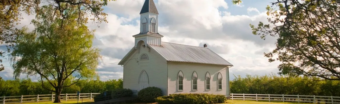 Pequeña iglesia blanca con campanario en el campo