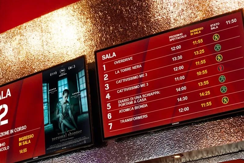 Paneles digitales con los horarios de las películas en el vestíbulo de un cine