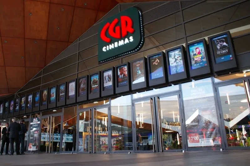Entrada de un cine con una hilera de carteles de películas digitales