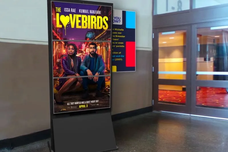 Pantalla con un cartel de película digital en un pasillo de un cine