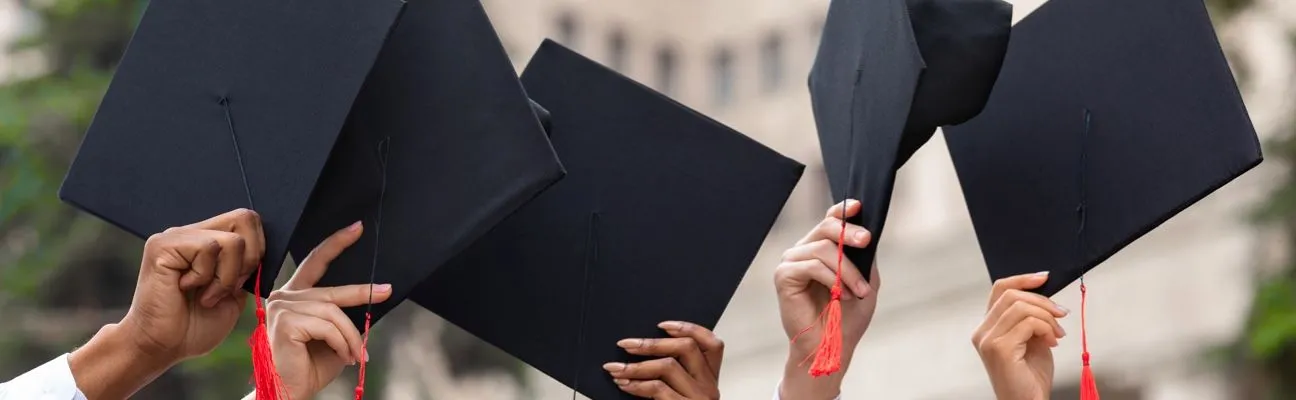 Birretes de graduación lanzados al aire