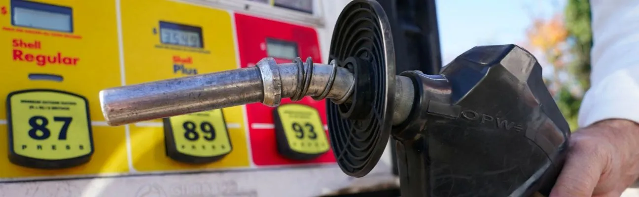 Mano sosteniendo una manguera de combustible en un surtidor