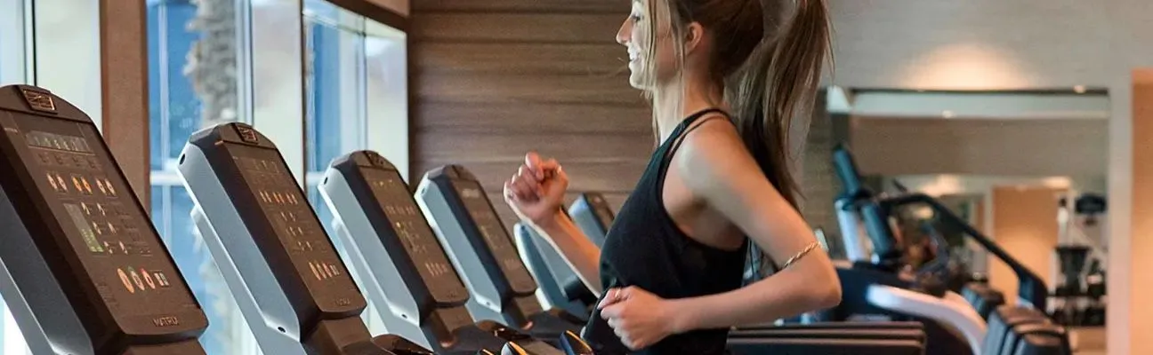 Personas corriendo en cintas de correr en un gimnasio