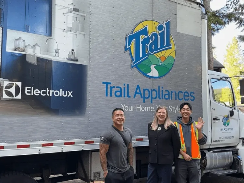 Equipo de Trail Appliances delante de un camión de reparto